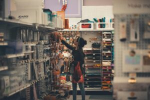 Woman shopping in a grocery store aisle, symbolizing rising everyday costs and inflation pressures.