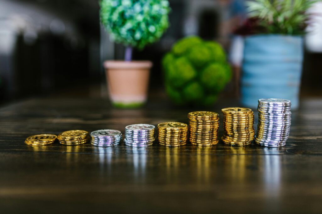 Stacks of coins on a table symbolizing importance of trusting the process in saving money.