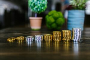 Stacks of coins on a table symbolizing importance of trusting the process in saving money.