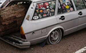 Car parked on the side of the road with a flat tire, representing unexpected expenses and the importance of emergency funds.