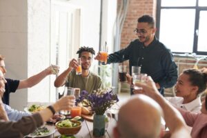 A family gathered around a Thanksgiving table, sharing food and toasting together during a holiday meal.