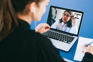 Person on a Zoom call while an AI meeting tool analyzes the conversation on screen, reflecting how AI meeting tools shape real-time communication.